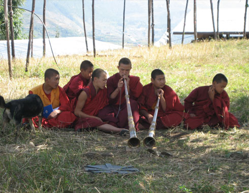 Young monks sitting in the grass.